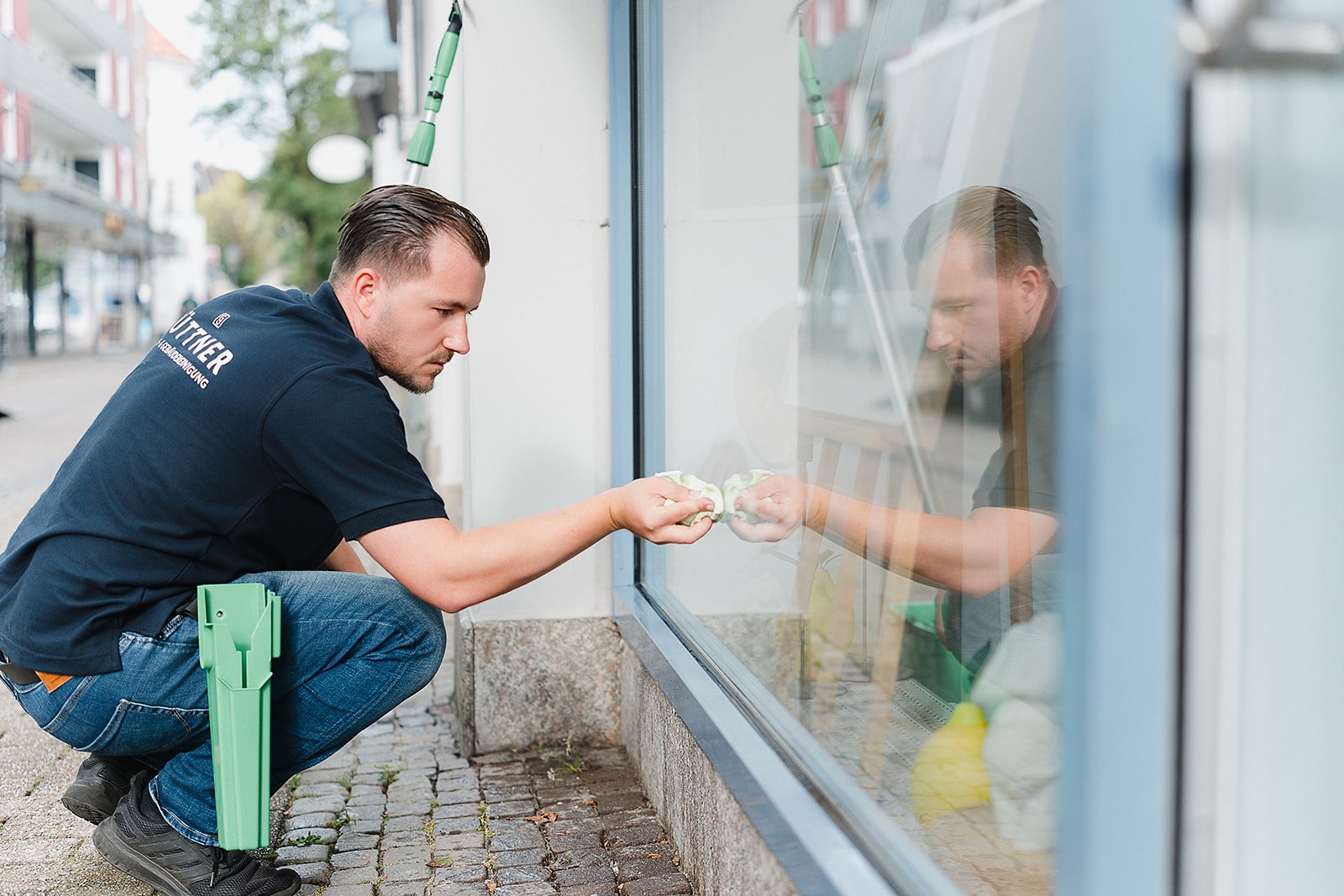 Reinigung eines Schaufensters, durch die Scheibe fotografiert