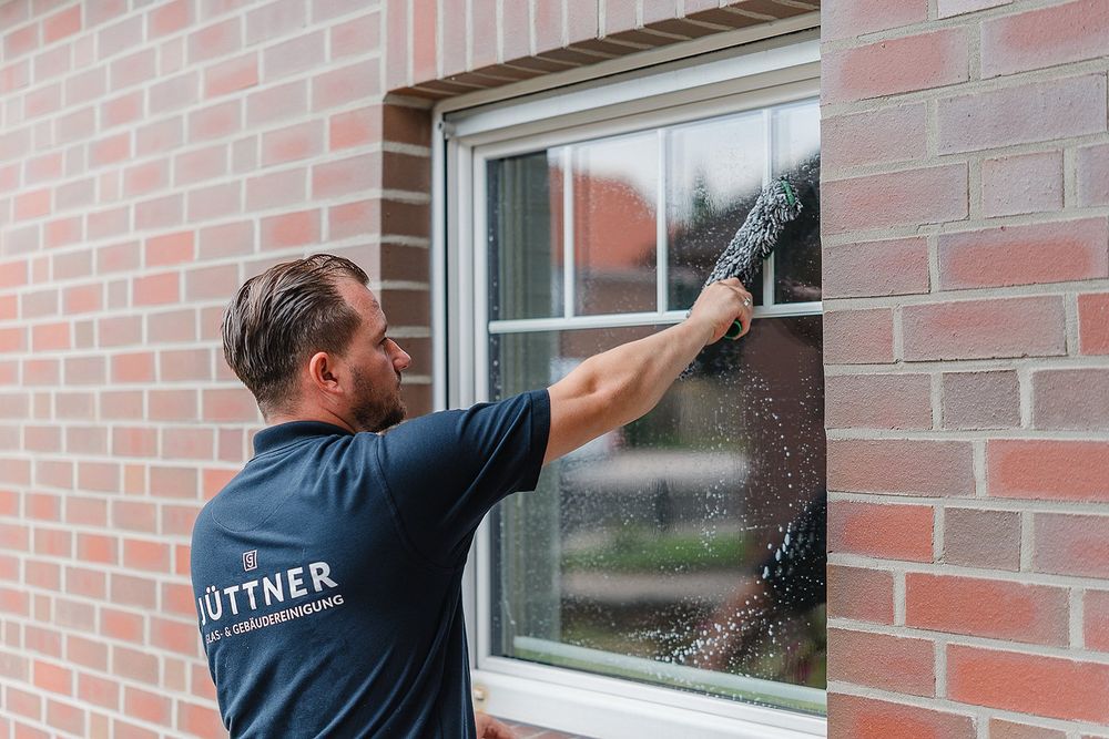 Fensterreinigung an einem privaten Wohnhaus mit Teleskop-Wischer