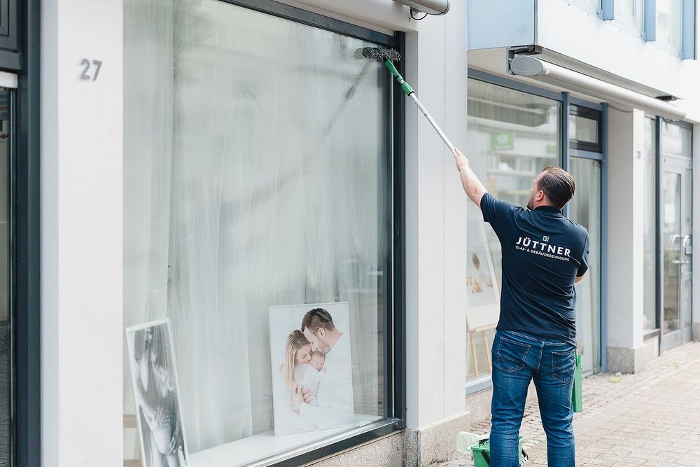 Florian Jüttner bei der Reinigung eines Schaufensters mit Teleskop-Wischer
