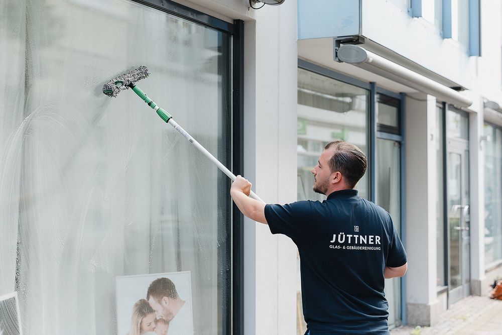 Reinigung eines Schaufensters für ein Geschäft mit Teleskop-Wischer