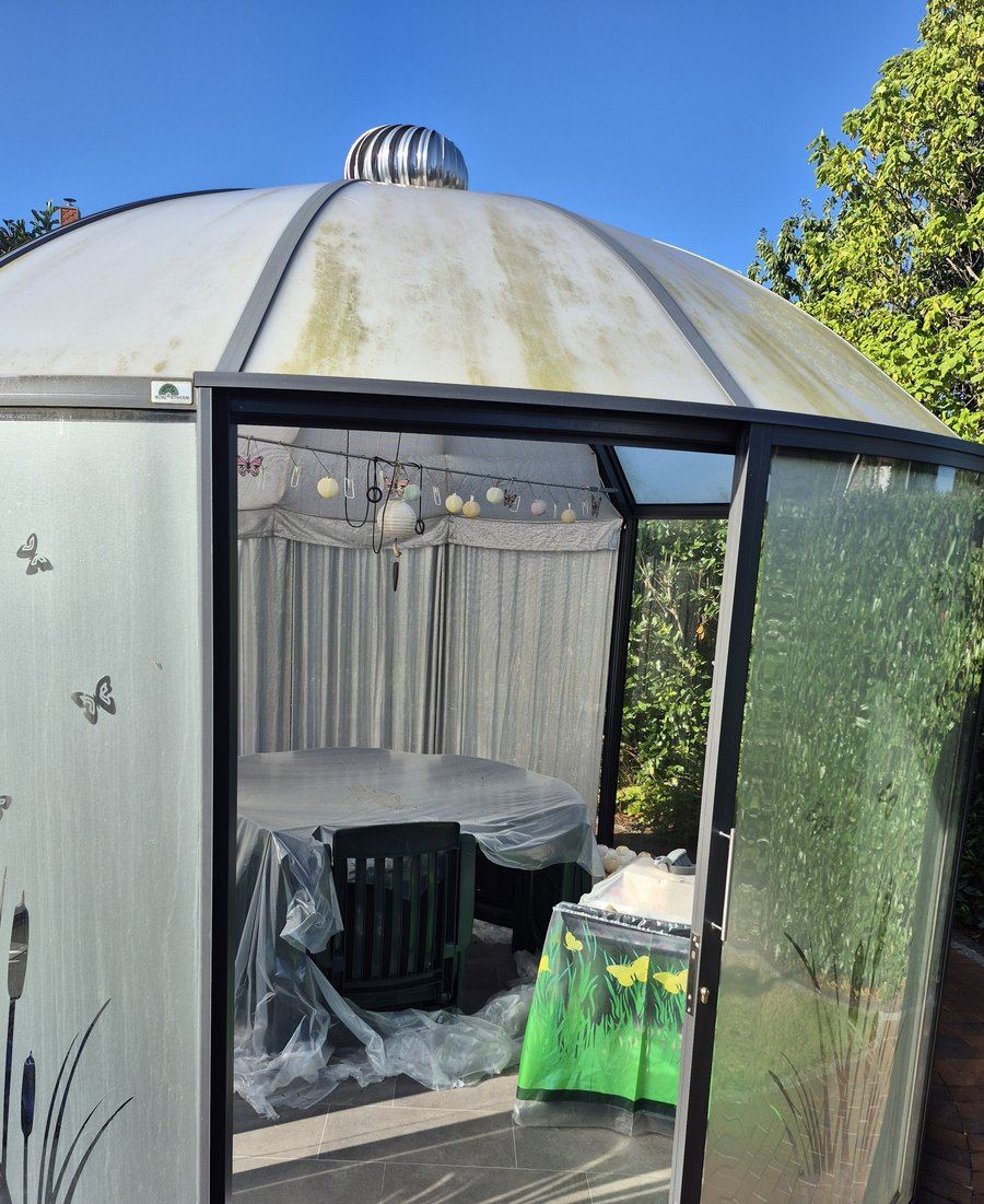Kuppelpavillon vor der Reinigung, mit Algen- und Wetterflecken auf dem Dach